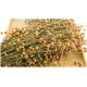 Eine Nahaufnahme von getrockneten Leinsamenstängeln mit goldenen Samenkapseln, auf einem Holztablett angeordnet, die ihre natürliche Textur zeigt.