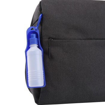 Nahaufnahme einer schwarzen Haustiertragetasche mit einem blauen Flaschenhalter und einer weißen Flasche, die befestigt ist.