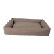 Ein rechteckiges, plüschiges Haustierbett mit erhöhten Rändern, das mit einem weichen, beigen Bezug und einer flachen Schlafoberfläche ausgestattet ist.