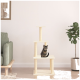 Eine getigerte Katze sitzt auf einem beigen Kratzbaum mit drei Plattformen, neben einem grünen Sofa und einer Topfpflanze in einem modernen Wohnzimmer.