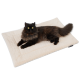Eine flauschige schwarze Katze mit gelben Augen, die auf einem weichen, cremefarbenen Haustierbett liegt.