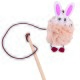 Ein flauschiges pinkes Kaninchen-Spielzeug, das an einem Holzstock mit einer Schnur befestigt ist, entworfen für das Spiel mit Haustieren.