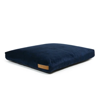 Navy-blaues Haustierbett mit einer weichen, plüschigen Oberfläche und einem kleinen Lederetikett an der Seite, entworfen für Komfort und Stil.