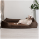 Ein weißer Hund, der auf einem braunen Haustierbett in einem modernen Raum mit einer Pflanze und einer dekorativen Lampe im Hintergrund entspannt.
