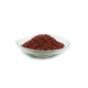 Ein Glasbehälter gefüllt mit einem Haufen kleiner, runder, rötlich-brauner Haustierfutterpellets.