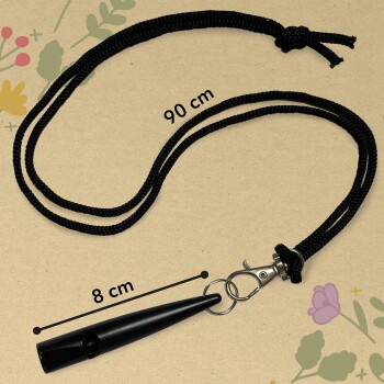 Schwarze Haustiertrainingspfeife mit einem 90 cm langen geflochtenen Kabel und einer 8 cm langen Pfeife, vor einem floralen Hintergrund.