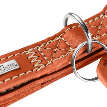 Nahaufnahme eines orangefarbenen Lederhundehalsbands mit cremefarbener Naht, Metall-D-Ring und kleinem 'HUNTER'-Anhänger.