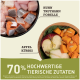 Rohe Haustierfutterzutaten in einer Schüssel: Huhn, Truthahn, Forelle, Apfel und Kürbis. Text bemerkt "70% hochwertige tierische Zutaten."