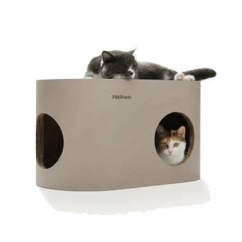 Graue Katze schläft auf einem beigen zylindrischen PëtRhein Katzenhaus, eine dreifarbige Katze lugt aus einer runden Seitenöffnung.