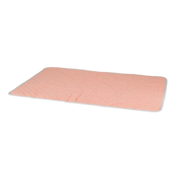 Un tapis pour animaux doux et matelassé de couleur pêche clair avec une bordure blanche, conçu pour le confort et la détente des animaux.