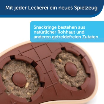 Haustierspielzeug mit Snackringen, mit einer braunen Silikonbasis und getreidefreien Leckereien, mit Text über Zutaten auf Deutsch.