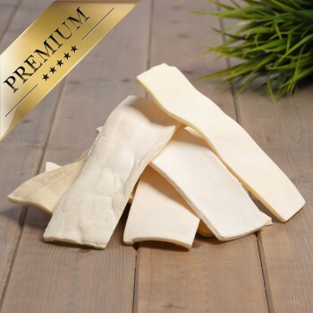 Premium-Hundekauartikel, gestapelt auf einer Holzoberfläche, mit einem goldenen "PREMIUM"-Etikett in der oberen linken Ecke.