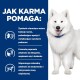 Uśmiechnięty biały pies samojed z boku tekstu opisującego, jak karma dla psów wspomaga funkcje nerek, apetyt i utrzymanie mięśni.