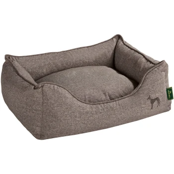 Hundesofa Boston braun M Graues Hundebett mit erhöhten Seiten und einem plüschigen Kissen, mit einer kleinen Hundesilhouette und einem grünen Etikett.