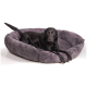 Ein schwarzer Labrador Retriever liegt bequem in einem plüschigen, grauen Haustierbett mit gerippter Textur.