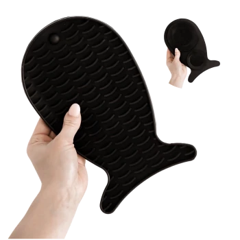 Eine Person hält einen schwarzen Silikon-Haustierpflegehandschuh in Fischform, mit einer strukturierten Oberfläche für effektives Bürsten.