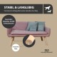 Ein stilvolles pinkes Haustiersofa mit Holzbeinen, ausgestattet mit zwei hellblauen Kissen, auf einem Holzboden vor einer schlichten Wand.