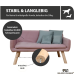 Ein stilvolles pinkes Haustiersofa mit Holzbeinen, ausgestattet mit zwei hellblauen Kissen, auf einem Holzboden vor einer schlichten Wand.