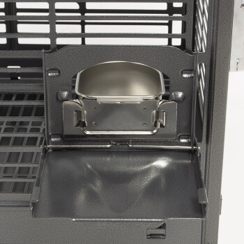Nahaufnahme eines dunkelgrauen Haustierkäfigs mit einem Halter für eine Futterschüssel aus Edelstahl und einer herausziehbaren Schublade zur einfachen Reinigung.