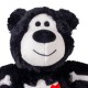 Plush black-and-white stuffed animal with round black nose, stitched smile and white bone-shaped patches on its chest