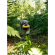 Ein flauschiger Hund mit einem grau-weißen Fell trägt ein gelbes Spielzeug im Mund, während er durch einen üppigen grünen Wald läuft.