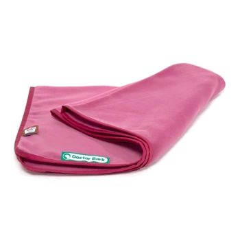 Eine gefaltete pinke Haustierdecke mit einem grünen "Doctor Bark"-Label und einem kleinen Anhänger in der Ecke, die ihre weiche Textur zeigt.