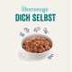 Schüssel mit Haustierfutter mit einer strukturierten, fleischigen Erscheinung, umgeben von verspielten Pfotenabdrücken; der Text lautet 'Überzeuge DICH SELBST.'
