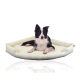 Ein schwarz-weißer Border Collie liegt bequem auf einem weichen, hellgrünen Hundebett mit gestreiftem Design.