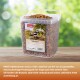 Behälter mit getrockneten Mehlwürmern von PANTO für Vögel, 900g beschriftet, auf einer Holzoberfläche mit grünem unscharfem Hintergrund.