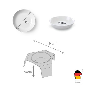 Eine grau-weiße Katze sitzt neben einer modernen weißen erhöhten Futterschüssel, die mit trockenem Katzenfutter auf einem Holzboden gefüllt ist.