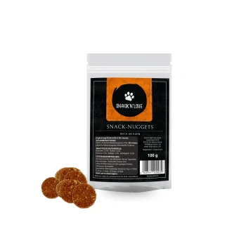 Opakowanie "Snack'n'Love Snack-Nuggets" dla psów, z czarno-pomarańczowym wzorem i czterema brązowymi nuggetami z przodu.