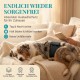 Eine Frau liegt auf einem Bett neben einem Hund, der eine blaue Hundewindel trägt. Der Text darüber lautet "Große Bewegungsfreiheit Ganz ohne Auslaufen."