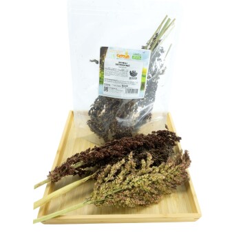 Getrocknete Grasbündel in einer klaren Tüte mit der Aufschrift 'Schelli Getrocknet' auf einem Holztablett, geeignet für den Verzehr durch Haustiere.