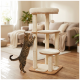 Getigerte Katze kratzt an einem beigefarbenen mehrstöckigen Kratzbaum mit gepolsterten Liegeflächen und herabhängenden Bommel in einem Wohnzimmer.