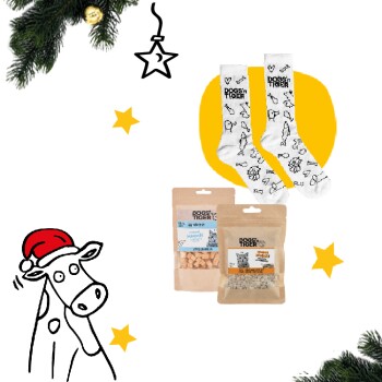 Ein festliches Bild mit zwei Packungen Haustierleckereien, die mit "HUNDE TIGER" beschriftet sind, einem Paar gemusterter Socken und einer Cartoon-Kuh mit einem Weihnachtsmannhut.