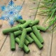 Grüne zylindrische gefriergetrocknete Tierleckerlis auf Holzbrett mit Gras und blauem Schneeflocken-Schriftzug 'Gefrier-getrocknet'