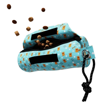Eine blaue Hundeleckerlitasche mit einem verspielten Design, das Cartoon-Hunde und Knochen zeigt, die braune Hundeleckerlis ausspucken.