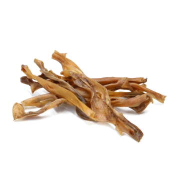Ein Haufen getrockneter, zäher Hundeleckerlis, die langen, dünnen Fleischstreifen ähneln, vor einem weißen Hintergrund.