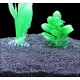 Aquariumsubstrat mit schwarzem Kies, mit zwei künstlichen Pflanzen: einer hohen, grünen, federartigen Pflanze und einer kürzeren, blattgrünen Pflanze.