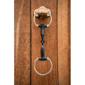 Ein schwarzer und silberner Pferdegebiss-Türklopfer, montiert auf einer Holzoberfläche.