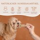 Ein flauschiger hellbrauner Hund leckt einen knochenförmigen Leckerbissen, der von einer Hand gehalten wird, mit dem Text "Natürlicher Hundekauartikel" und aufgelisteten Eigenschaften.