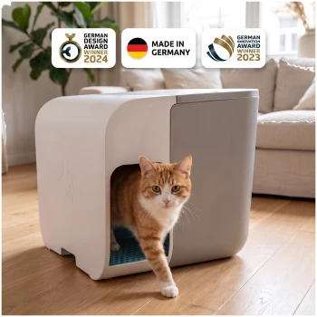 Eine graue und blaue Katzentoilette mit der Aufschrift "COLD DIGGER" und einer Schaufel, neben einer neugierigen getigerten Katze und Auszeichnungssymbolen für 2024 und 2023.