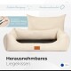 Ein beiges Haustierbett mit abnehmbarem Bezug, das ein weiches Kissen und seitliche Bolster aufweist, beschriftet mit 'Herausnehmbares Liegekissen' und 'Einfach Reinigung.'