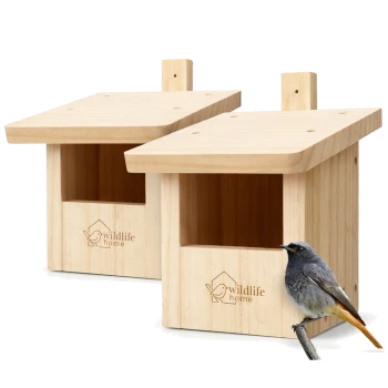 Zwei Nistkästen aus hellem Holz mit Gravur 'wildlife home', offenen Eingängen und einem kleinen grau-orangen Vogel, der davor sitzt