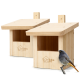Zwei Nistkästen aus hellem Holz mit Gravur 'wildlife home', offenen Eingängen und einem kleinen grau-orangen Vogel, der davor sitzt