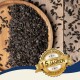 Eine Holzschale mit schwarzen Sonnenblumenkernen, einige auf einer Holzoberfläche verstreut, mit einem Abzeichen, das "Beste Qualität" und "10 Jahre" liest.