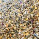 Eine Nahaufnahme einer bunten Mischung aus Samen, Körnern und getrockneten Kräutern, ideal für Haustierfutter oder Leckereien.