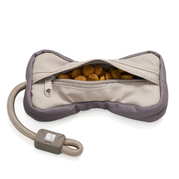 Knochenförmiges, beige-graues Leckerli-Reißverschlusstäschchen, gefüllt mit Trockenfutter, mit Tau-Schlaufengriff und kleinem Etikett mit weißem Logo.