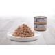 A plate of shredded tuna with shrimp, accompanied by two cans of Almo Nature cat food in the background.