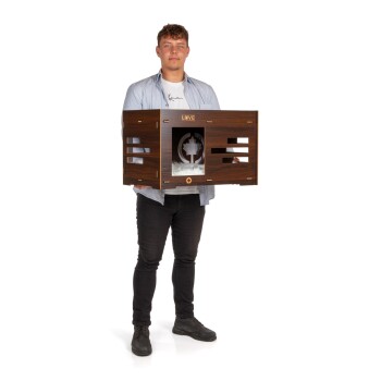 Eine Person hält eine stilvolle Holzhundetransportbox mit einem Ausschnittdesign und weichem Futter im Inneren, beschriftet mit 'LOVE' auf der Vorderseite.